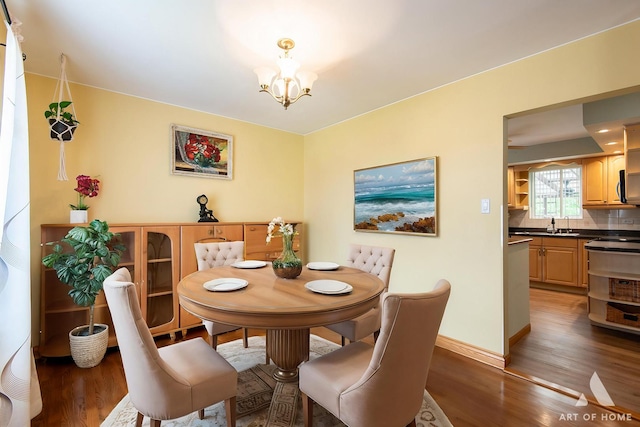 4010 Bobby Ln, Schiller Park, IL 60176 - dining room featuring a chandelier, wood finished floors, and baseboards