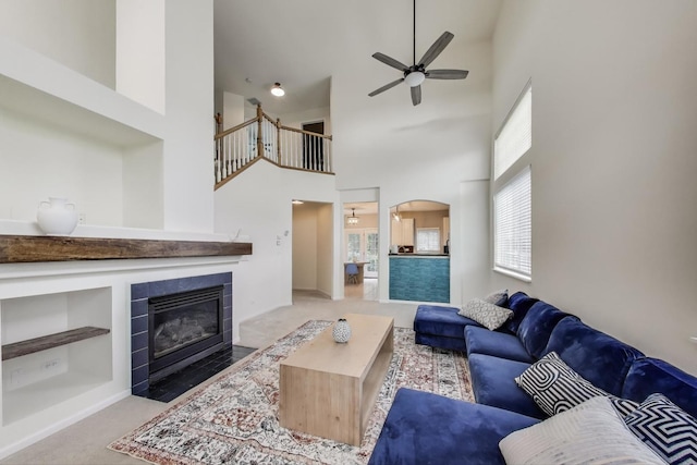 31905 Millard Cir, Warrenville, IL 60555 - living area with carpet flooring, a ceiling fan, a tile fireplace, a towering ceiling, and arched walkways