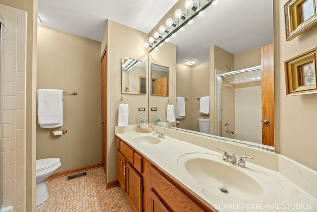 26W568 Lindsey Ave, Winfield, IL 60190 - bathroom featuring toilet, double vanity, a tile shower, tile patterned floors, and baseboards