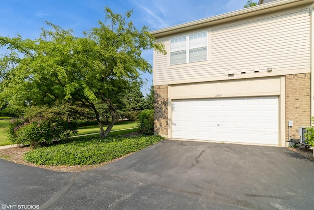 1292 Georgetown Way Unit 1292, Vernon Hills, IL 60061 - view of property exterior featuring brick siding, driveway, and an attached garage