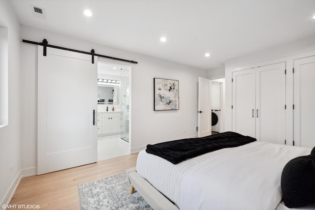 6947 N Overhill Ave, Chicago, IL 60631 - bedroom with a barn door, light wood-style flooring, recessed lighting, ensuite bathroom, and baseboards