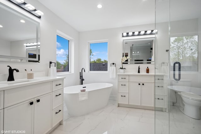 6947 N Overhill Ave, Chicago, IL 60631 - full bathroom with two vanities, marble finish flooring, recessed lighting, and a freestanding tub