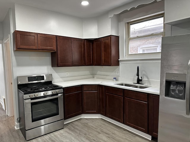 7621 S Eberhart Ave, Chicago, IL 60619 - kitchen with stainless steel appliances, a sink, light countertops, light wood finished floors, and dark brown cabinetry