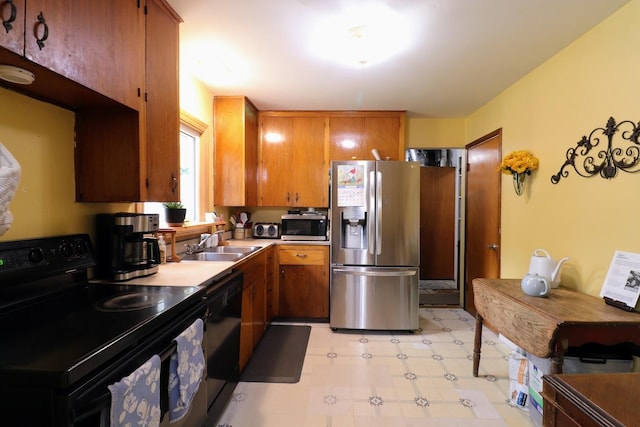 80 Flagstaff Ln, Hoffman Estates, IL 60169 - kitchen with black appliances, a sink, light flooring, brown cabinetry, and light countertops