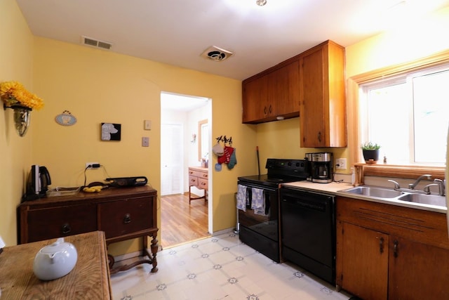 80 Flagstaff Ln, Hoffman Estates, IL 60169 - kitchen with black appliances, light flooring, a sink, light countertops, and brown cabinetry