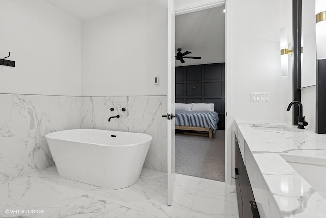 2633 N Emmett St Unit 1F, Chicago, IL 60647 - ensuite bathroom featuring double vanity, a soaking tub, marble finish flooring, wainscoting, and a ceiling fan