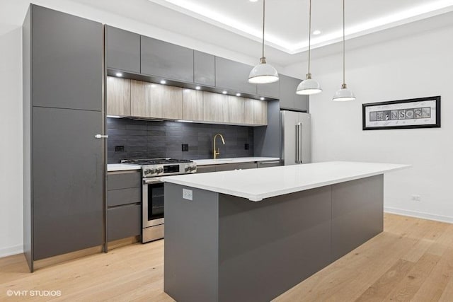 2633 N Emmett St Unit 1F, Chicago, IL 60647 - kitchen featuring stainless steel appliances, modern cabinets, decorative backsplash, light wood-style flooring, and recessed lighting