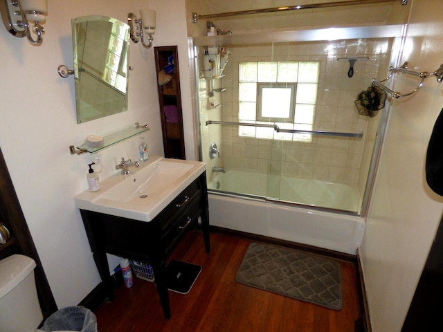 21 Woodland Ave, Elgin, IL 60123 - bathroom featuring toilet, wood finished floors, vanity, and enclosed tub / shower combo
