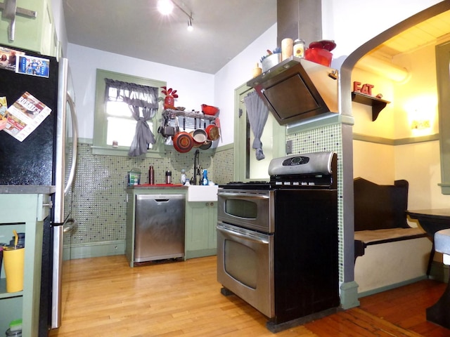 21 Woodland Ave, Elgin, IL 60123 - kitchen featuring stainless steel appliances, light wood-style flooring, a sink, and arched walkways