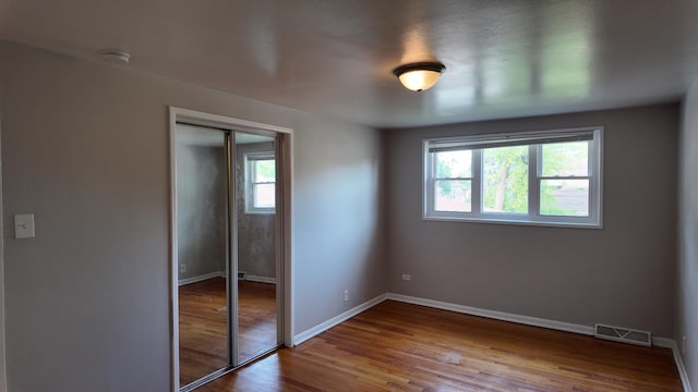 15965 Debbie Ln, South Holland, IL 60473 - unfurnished bedroom featuring multiple windows, a closet, wood finished floors, and baseboards