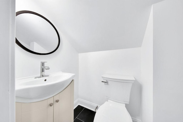 7501 S Aberdeen Ave, Chicago, IL 60620 - half bathroom featuring toilet, vanity, tile patterned floors, vaulted ceiling, and baseboards