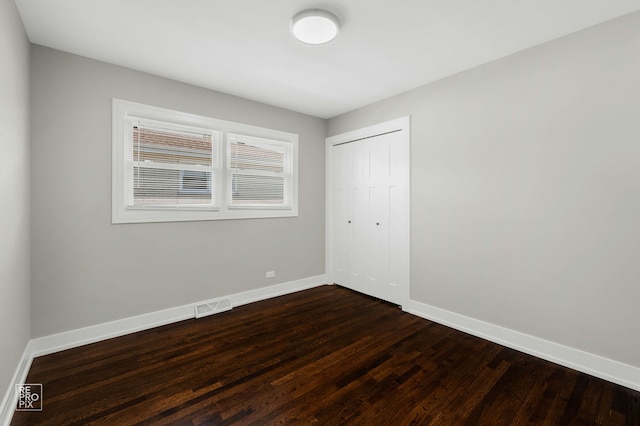 1166 S Highland Ave, Arlington Heights, IL 60005 - unfurnished bedroom with baseboards, dark wood-style flooring, and a closet