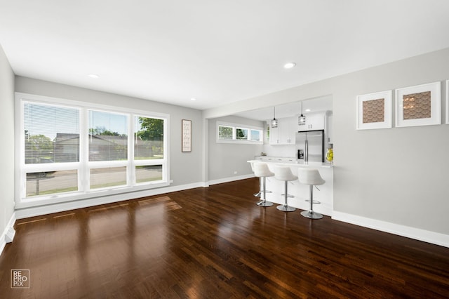 1166 S Highland Ave, Arlington Heights, IL 60005 - kitchen with stainless steel fridge with ice dispenser, a breakfast bar area, baseboards, dark wood finished floors, and white cabinetry