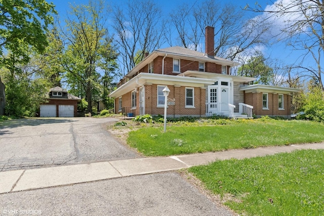 1005 Division St, Lisle, IL 60532 - view of front facade featuring brick siding, a chimney, an outdoor structure, a front yard, and a detached garage