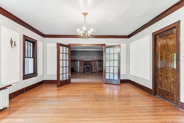 1005 Division St, Lisle, IL 60532 - unfurnished living room featuring french doors, light wood-type flooring, baseboards, ornamental molding, and a chandelier