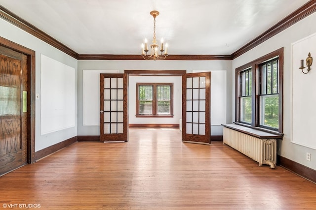 1005 Division St, Lisle, IL 60532 - unfurnished room featuring radiator, healthy amount of natural light, crown molding, wood-type flooring, and a chandelier