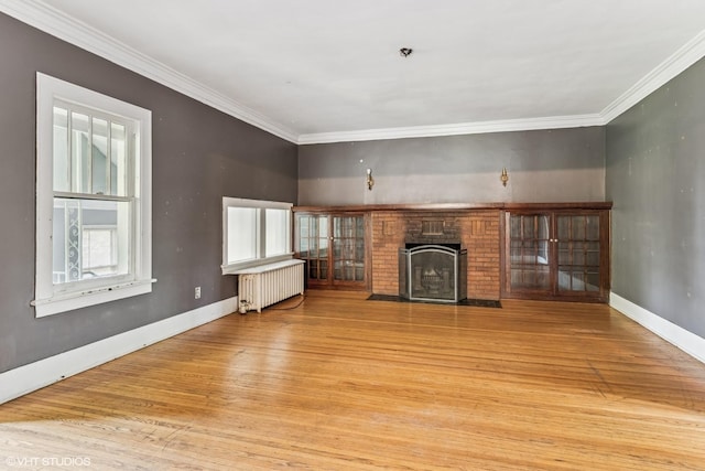 1005 Division St, Lisle, IL 60532 - unfurnished living room with radiator, wood finished floors, a brick fireplace, ornamental molding, and baseboards