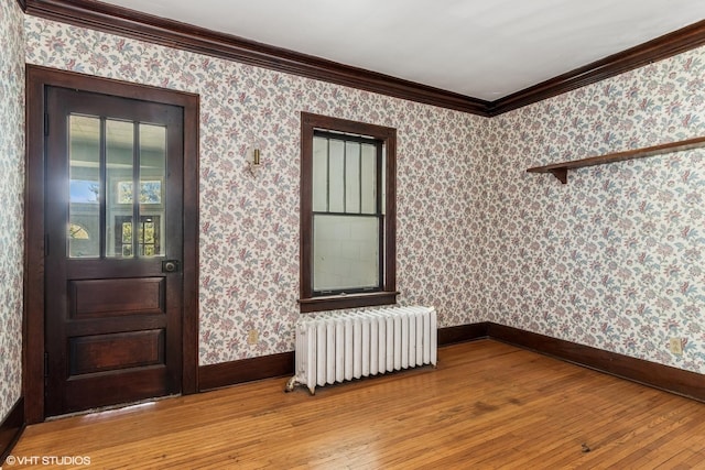 1005 Division St, Lisle, IL 60532 - spare room featuring radiator, light wood-type flooring, baseboards, crown molding, and wallpapered walls