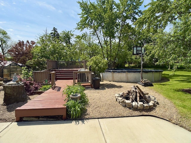 9113 Elm Cir, Hickory Hills, IL 60457 - view of patio / terrace with a covered pool, an outdoor fire pit, a wooden deck, a greenhouse, and an outbuilding