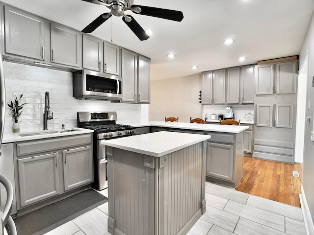 9113 Elm Cir, Hickory Hills, IL 60457 - kitchen with gray cabinetry, appliances with stainless steel finishes, a kitchen island, a sink, and backsplash