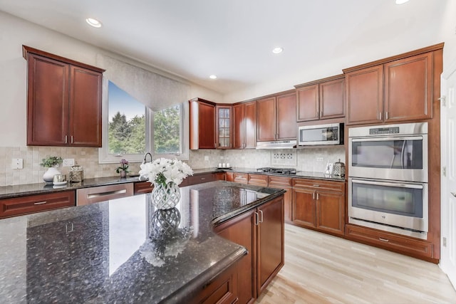 2013 Valor Ct, Glenview, IL 60026 - kitchen featuring appliances with stainless steel finishes, decorative backsplash, light wood-style floors, dark stone countertops, and recessed lighting