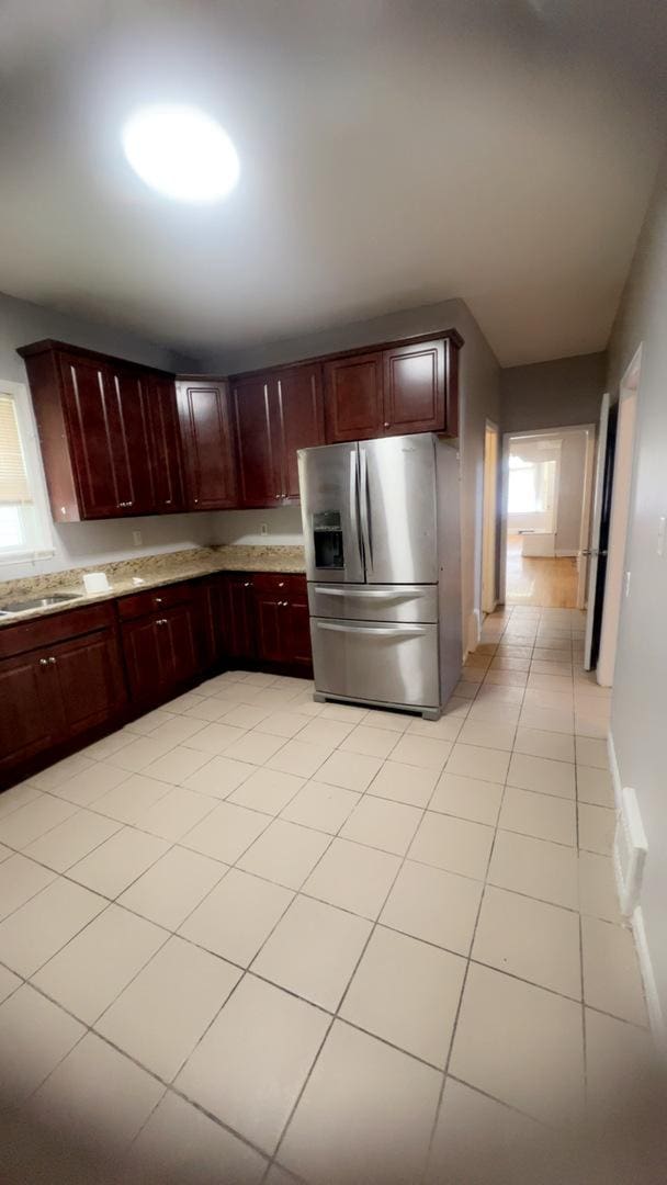 10643 S Calhoun Ave, Chicago, IL 60617 - kitchen featuring stainless steel fridge, reddish brown cabinets, light tile patterned floors, and a sink