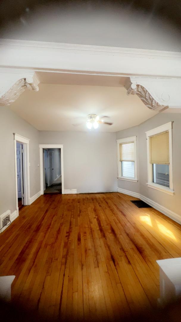 10643 S Calhoun Ave, Chicago, IL 60617 - spare room featuring wood-type flooring and baseboards