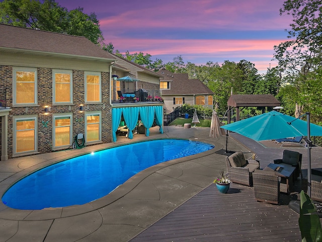 2010 Sleepy Hollow Rd, Sleepy Hollow, IL 60118 - pool at dusk featuring an outdoor pool, a wooden deck, and a patio area