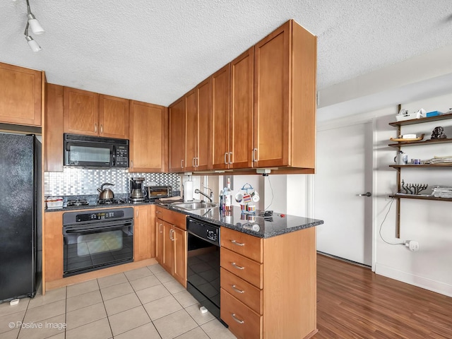 9715 Woods Dr Unit 1104, Skokie, IL 60077 - kitchen featuring black appliances, dark stone countertops, a sink, brown cabinets, and tasteful backsplash
