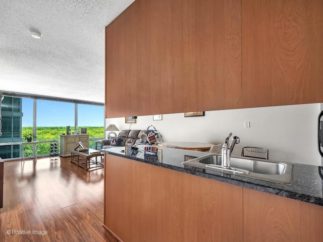 9715 Woods Dr Unit 1104, Skokie, IL 60077 - kitchen with expansive windows, a sink, wood finished floors, a textured ceiling, and dark stone counters