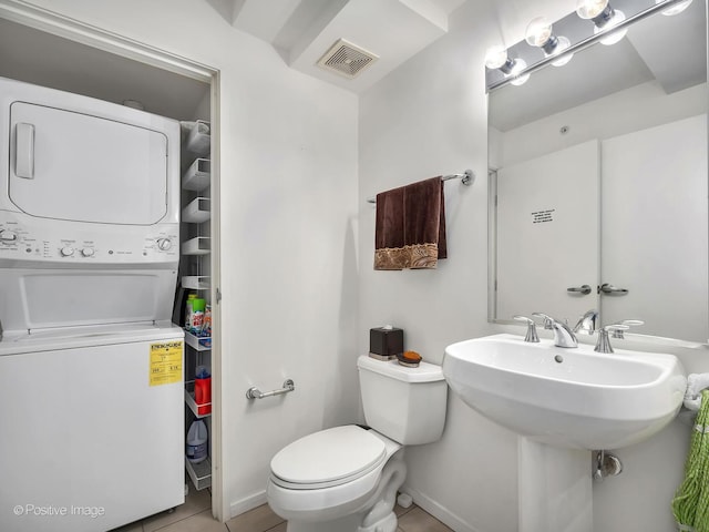 9715 Woods Dr Unit 1104, Skokie, IL 60077 - bathroom with estacked washer and dryer, toilet, and tile patterned floors