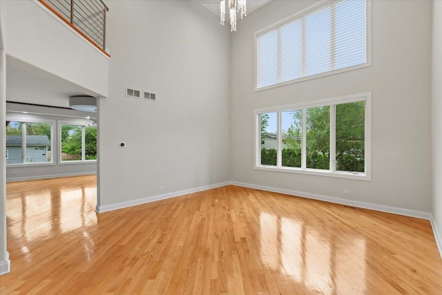 3 Crestview Ter, Buffalo Grove, IL 60089 - spare room with a towering ceiling, light wood-style flooring, baseboards, and a chandelier