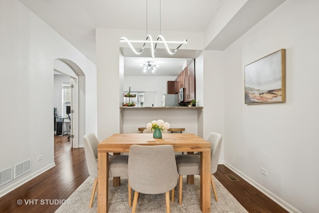 1263 Evergreen Ave, Des Plaines, IL 60016 - dining area with a chandelier, dark wood-type flooring, arched walkways, and baseboards