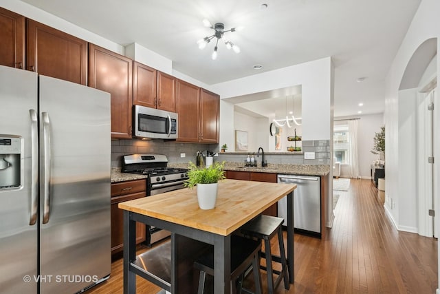 1263 Evergreen Ave, Des Plaines, IL 60016 - kitchen with appliances with stainless steel finishes, a chandelier, backsplash, dark wood-style floors, and recessed lighting