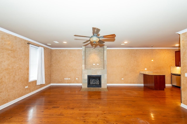 2612 W Diversey Ave Unit 101, Chicago, IL 60647 - unfurnished living room featuring crown molding, ceiling fan, wood finished floors, a tiled fireplace, and recessed lighting