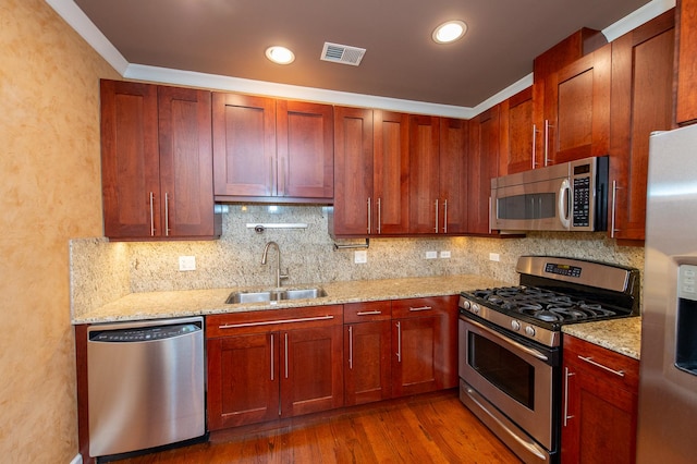 2612 W Diversey Ave Unit 101, Chicago, IL 60647 - kitchen with stainless steel appliances, a sink, decorative backsplash, dark wood finished floors, and recessed lighting