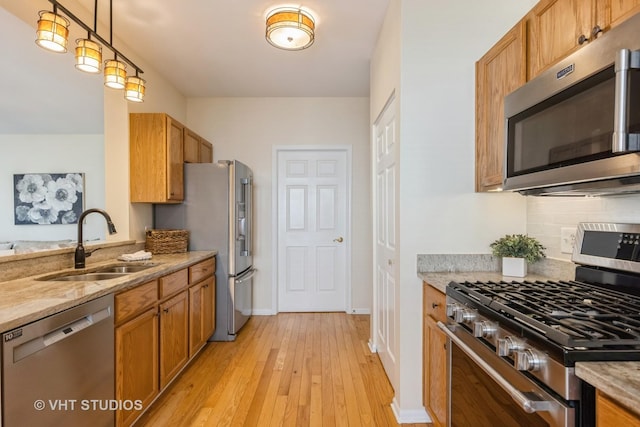 2831 Granite Ct, Crystal Lake, IL 60012 - kitchen featuring appliances with stainless steel finishes, a sink, backsplash, light wood-style floors, and light stone countertops