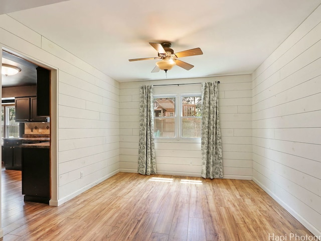 5501 Abbey Dr, Mchenry, IL 60050 - unfurnished room featuring light wood finished floors, a ceiling fan, wood walls, and baseboards