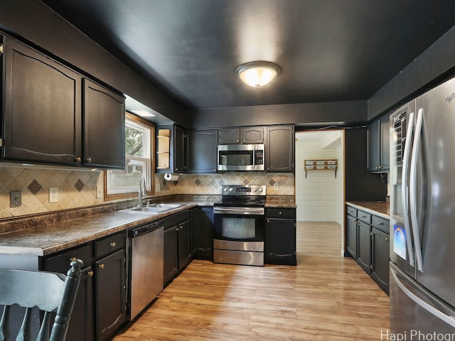 5501 Abbey Dr, Mchenry, IL 60050 - kitchen with stainless steel appliances, a sink, dark countertops, light wood-type flooring, and tasteful backsplash
