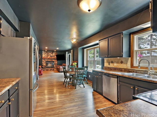 5501 Abbey Dr, Mchenry, IL 60050 - kitchen with stainless steel appliances, a sink, light wood-style flooring, open floor plan, and a stone fireplace