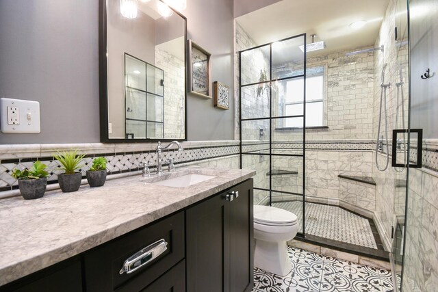 4419 N Racine Ave Unit 1N, Chicago, IL 60640 - bathroom with tile walls, toilet, vanity, a stall shower, and tile patterned floors