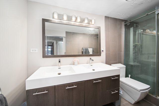 1221 N Dearborn St Unit 810S, Chicago, IL 60610 - bathroom featuring toilet, double vanity, and a shower stall