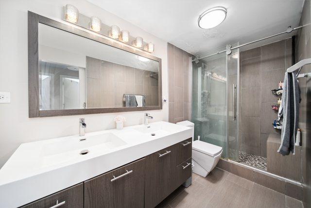 1221 N Dearborn St Unit 810S, Chicago, IL 60610 - full bathroom featuring a stall shower, double vanity, and toilet