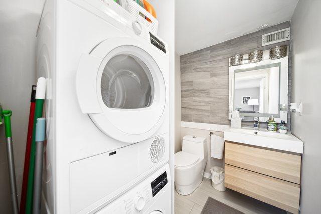 1221 N Dearborn St Unit 810S, Chicago, IL 60610 - bathroom featuring stacked washer / drying machine, vanity, toilet, and tile walls