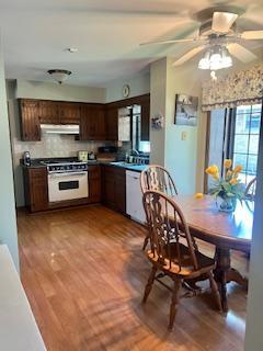 3824 Grove Ave, Western Springs, IL 60558 - kitchen with under cabinet range hood, white dishwasher, stove, tasteful backsplash, and dark brown cabinetry