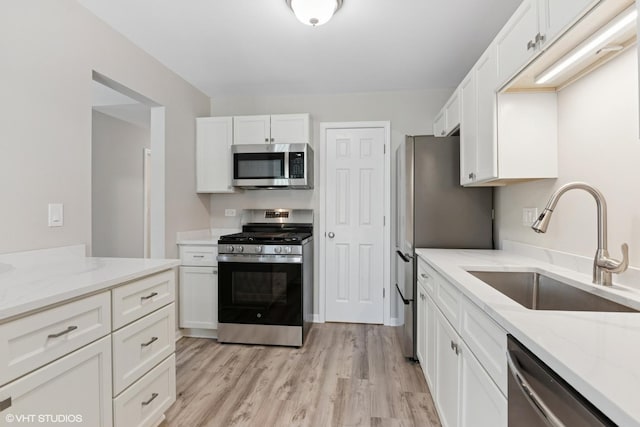 0N111 Windermere Rd Unit 2107, Winfield, IL 60190 - kitchen featuring appliances with stainless steel finishes, a sink, white cabinetry, and light stone countertops