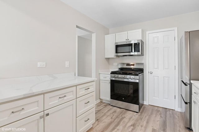 0N111 Windermere Rd Unit 2107, Winfield, IL 60190 - kitchen with appliances with stainless steel finishes, light wood finished floors, white cabinetry, and light stone counters