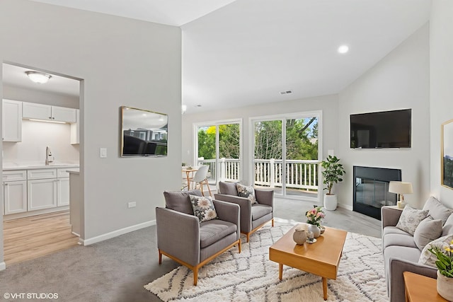 0N111 Windermere Rd Unit 2107, Winfield, IL 60190 - living room featuring lofted ceiling, baseboards, light colored carpet, and a glass covered fireplace