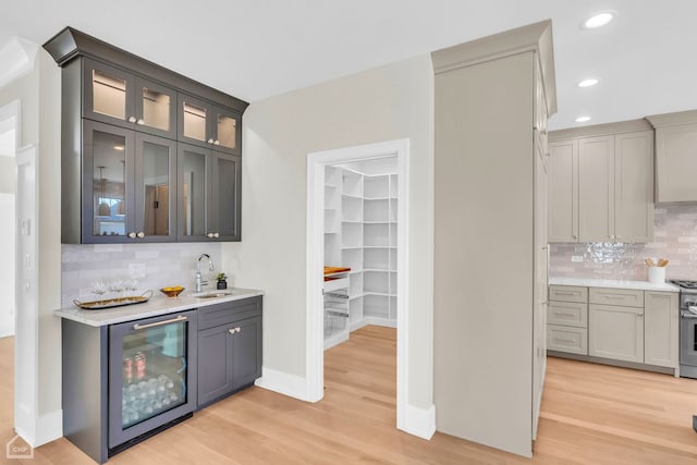 4920 Stonewall Ave, Downers Grove, IL 60515 - indoor wet bar with beverage cooler, light wood-style flooring, backsplash, recessed lighting, and baseboards