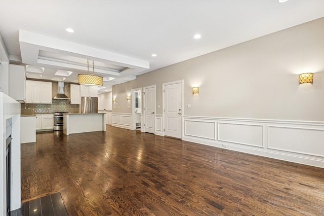 2004 W Erie St Unit 1W, Chicago, IL 60612 - unfurnished living room featuring a raised ceiling, recessed lighting, dark wood-style floors, a decorative wall, and wainscoting